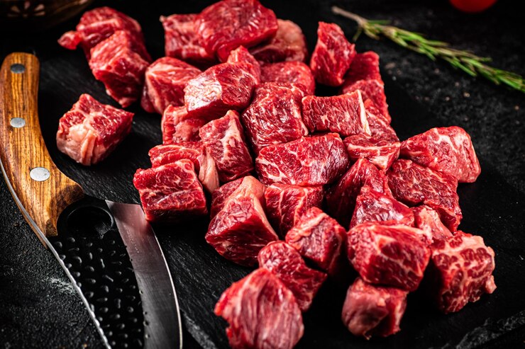 Photo ローズマリーの小枝とナイフを備えた石板の上の生の牛肉の部分