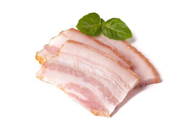 Raw pieces of fresh bacon with basil leaf green isolated on a white background