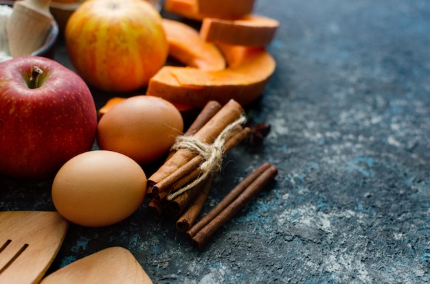 Raw pieces of pumpkin on a cutting board with rosemary