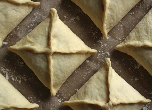 Raw pies in the form of squares in rows on a baking cart