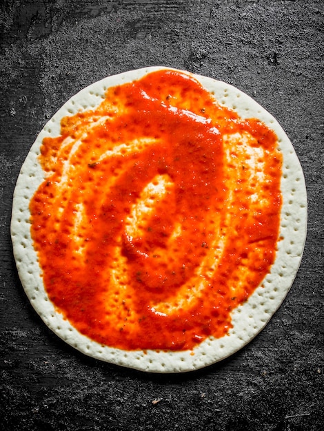 Raw pizza Rolled out dough with tomato paste