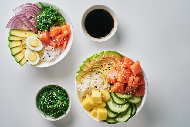 Poke bowl crudo con riso, avocado, salmone, mango, uova di quaglia