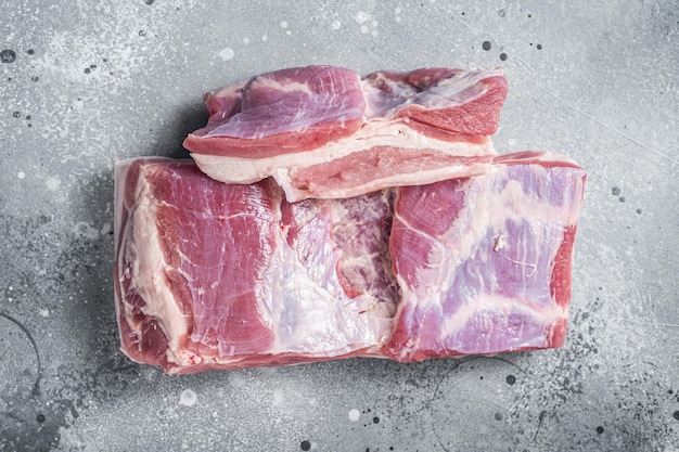 肉屋のテーブルに皮付き生豚バラ肉 灰色の背景 トップビュー