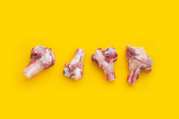 Raw pork bones on yellow background.