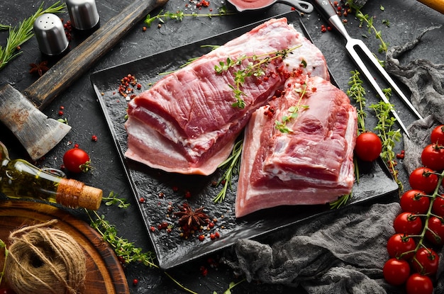 キッチンの背景に食材とスパイスが入った生の豚肉のブリスケット肉上面図素朴なスタイル