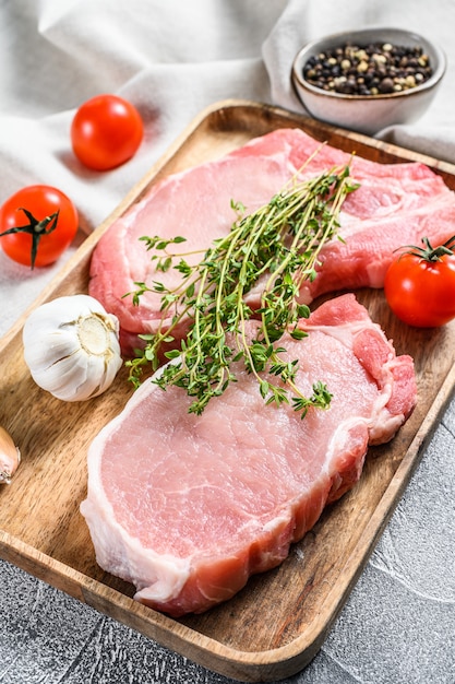 Raw pork cutlet. Organic meat steak. White background. Top view