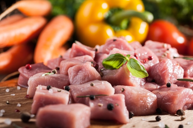 Raw pork  on cutting board and fresh vegetables on wooden table