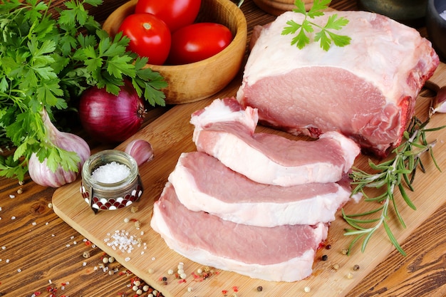 Raw pork fillet on a cutting board, cut into steaks