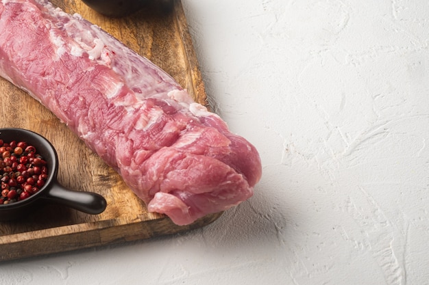 Raw pork fillet tenderloin. Fresh meat set, on wooden tray, on white stone