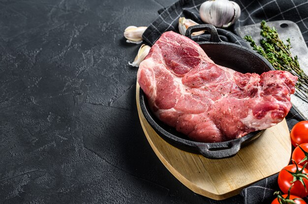 Raw pork meat on the bone, marble steak in a frying pan