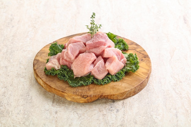 Raw pork meat cubes for coocking over board