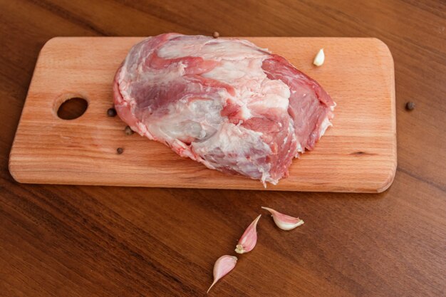 Raw pork meat on cutting board on a table