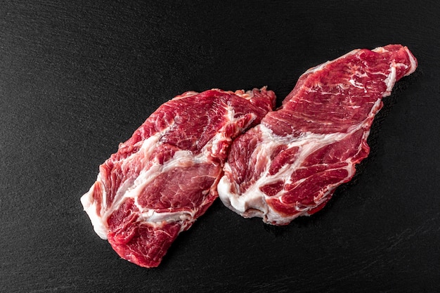 暗い石の背景に生の豚肉