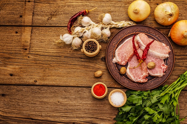 Raw pork meat. Fresh loin, spices, fragrant vegetables and parsley