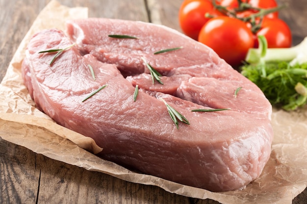 Raw pork meat and fresh vegetables on wooden table