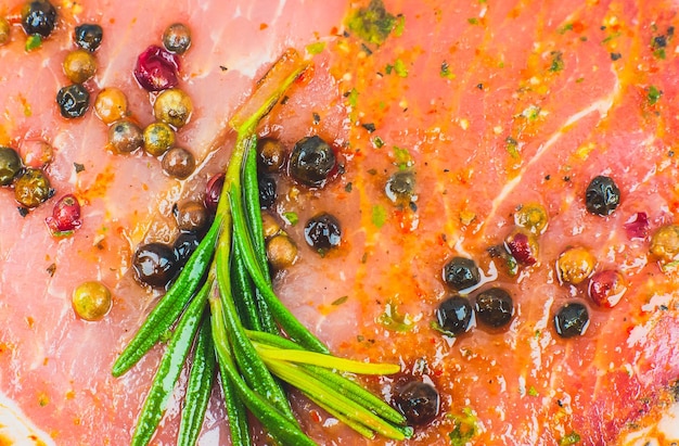 Raw Pork meat with spices and green rosemary herb Red meat texture background Raw ham Macro photo Fat Fresh juicy steak