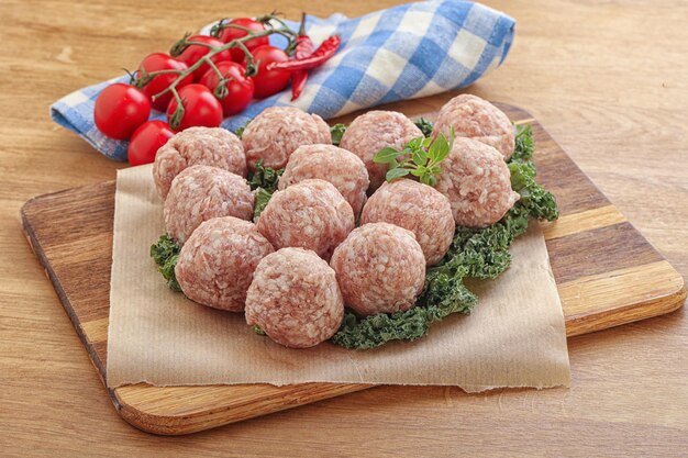 Photo raw pork meatball for cooking over board