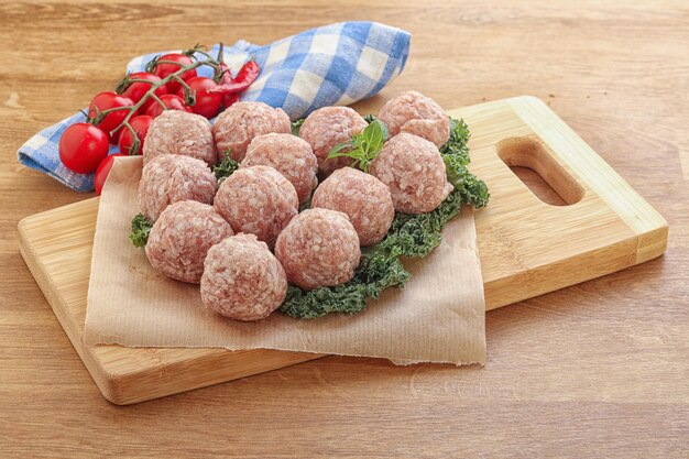 Raw pork meatball for cooking over board