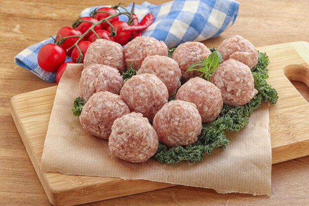 Raw pork meatball for cooking over board