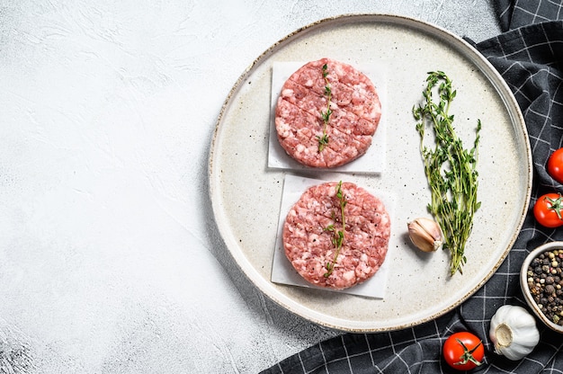 Raw pork patty, ground meat cutlets on a cutting Board. Organic mince. Gray background. Top view. Copy space.
