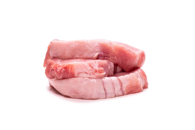 Raw pork pieces isolated on a white wall. Top view.