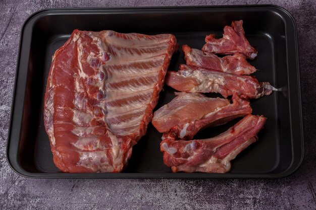 raw pork ribs on a black platter