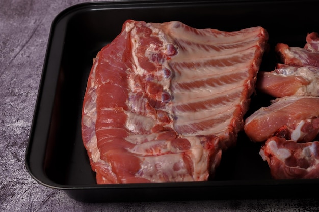 raw pork ribs on a black platter