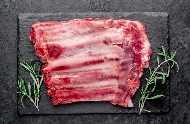 Photo raw pork ribs on a stone background