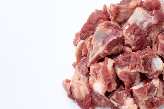 Raw pork ribs in white plate on white background.