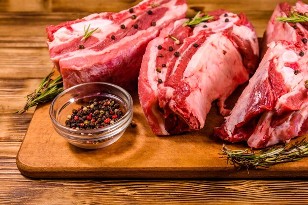 Raw pork ribs with spices and rosemary on a cutting board