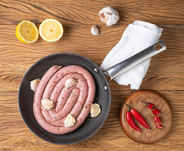 Raw pork sausage on a pan with silician lemon and seasonings