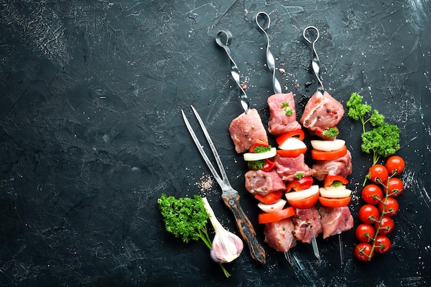 Raw pork shish kebab BBQ meat with vegetables and spices Top view Free space for your text Rustic style