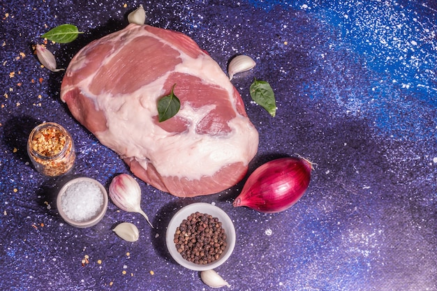 Raw pork shoulder cut. Fresh animal protein, spices, vegetables. Trendy hard light, dark shadow. Cosmic stone concrete background, top view