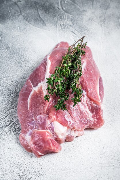 Raw pork shoulder meat on a butcher table. White table. Top view.