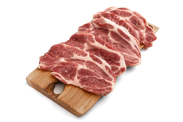 흰색 바탕에 나무 판자에 얇게 썬 생 돼지고기. 조각 원시 돼지고기의 힙입니다. 신선한 원시 쇠고기 양고기 흰색 절연입니다. 원시 스테이크의 힙