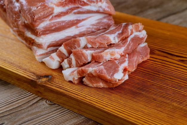 Raw pork slices prepared of fresh meat for cooking on wooden board