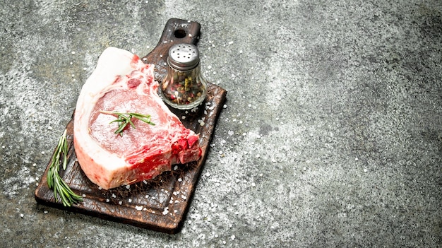 Raw pork steak with herbs and spices. on rustic background.