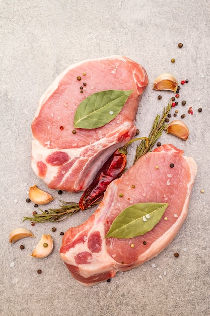 Raw pork steak with spices and dried herbs