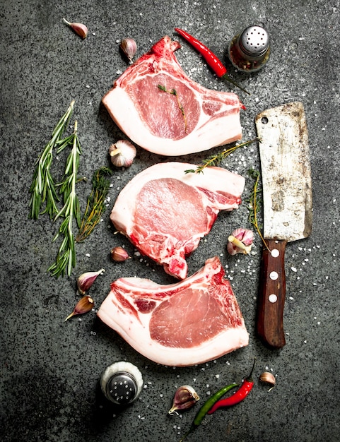 Raw pork steak with a sprig of rosemary and spices.