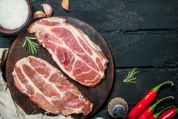 Raw pork steaks with aromatic and herbs and spices
