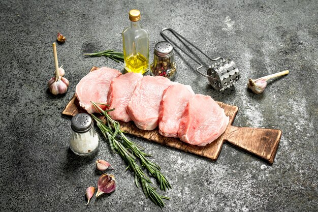 Raw pork steaks with herbs and spices.