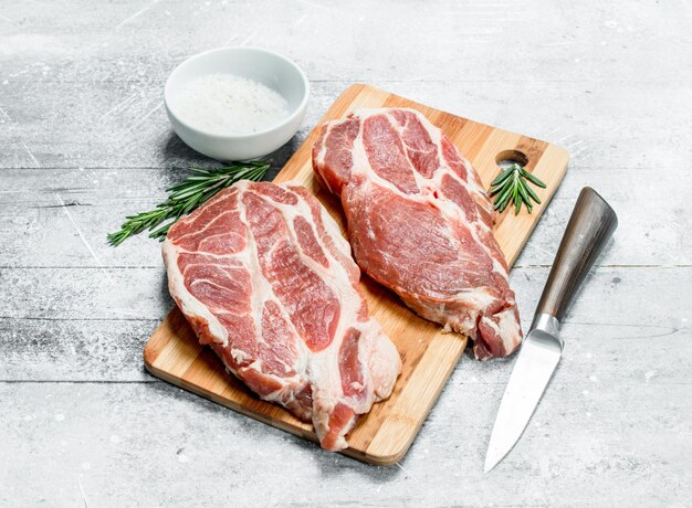 Raw pork steaks with salt