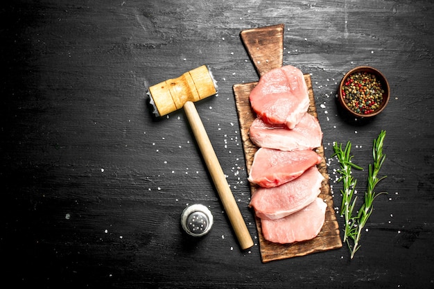 Raw pork steaks with spices and herbs.