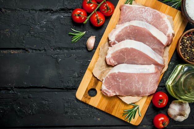 Raw pork steaks with tomatoes and spices