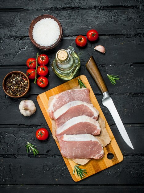 Raw pork steaks with tomatoes and spices