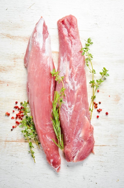 Raw pork tenderloin with spices on a white wooden background Meat Top view Rustic style