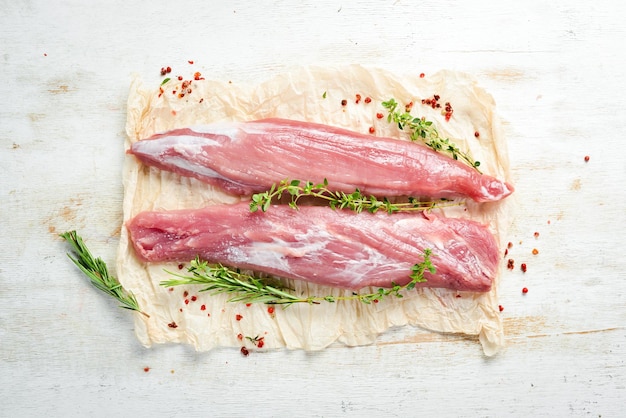 Raw pork tenderloin with spices on a white wooden background Meat Top view Rustic style