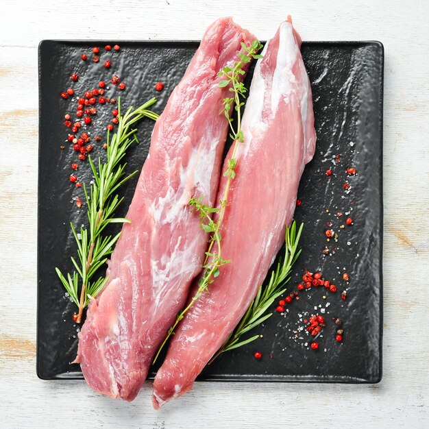 Raw pork tenderloin with spices on a white wooden background Meat Top view Rustic style