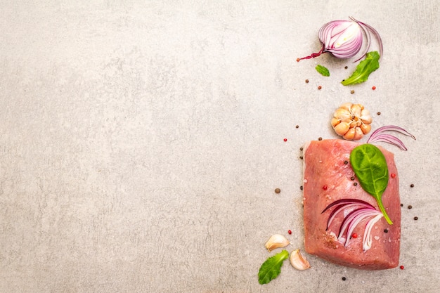 Raw pork tenderloin with vegetables and spices