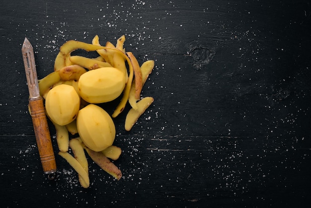 Raw potatoes on a black wooden background Cooking Free space for text Top view